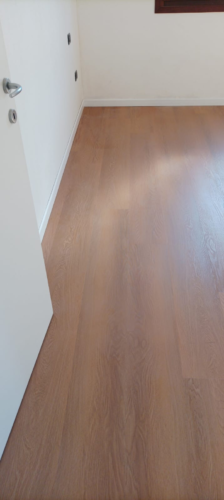 Porta bianca con maniglia cromo satinato e pavimento SPC effetto legno a Marcon